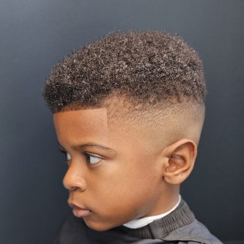 Young boy with a curly high top, a high fade and a crisp line-up at the forehead